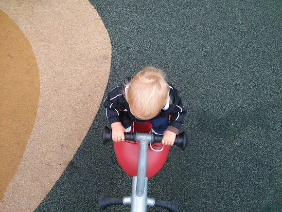 Standing on the bouncy toy at the park.