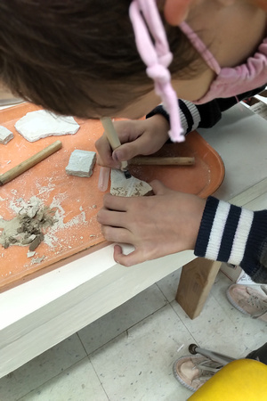Cleaning a fossil at Mission Science Workshop