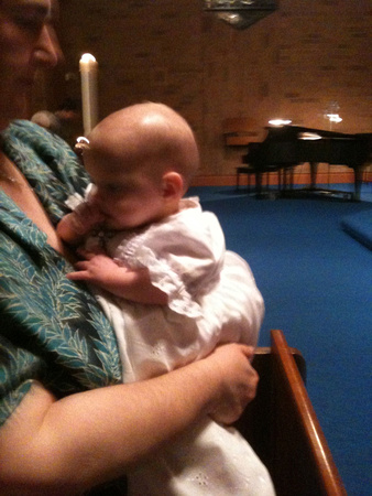 F noms RA's cross necklace during the Easter Vigil service in her fancy baptism dress