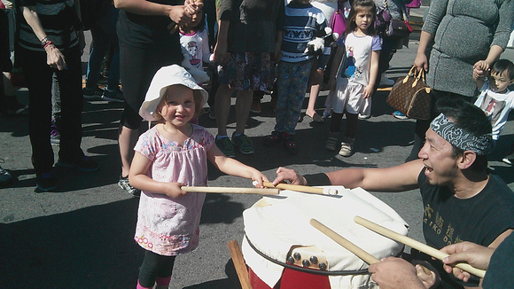 K learning how to drum at a local Japanese festival.