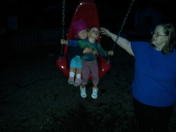 JA pushing both babies on a big red swing!