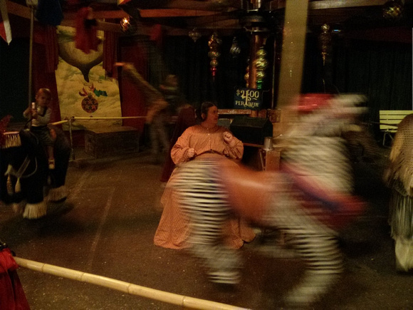 Babies on a human-powered merry-go-round at Dickens Fair.  The woman in the middle is telling a story about the African animals.