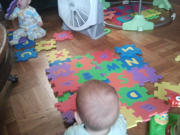 Babies taking apart the alphabet carpet.