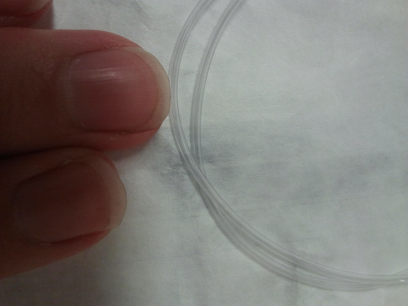 Close up of an infant catheter, with my fingers for scale.
