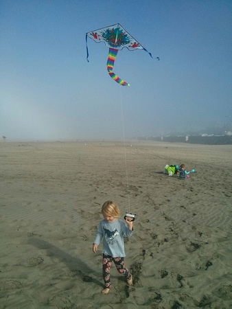 F flying a kite at the beach.